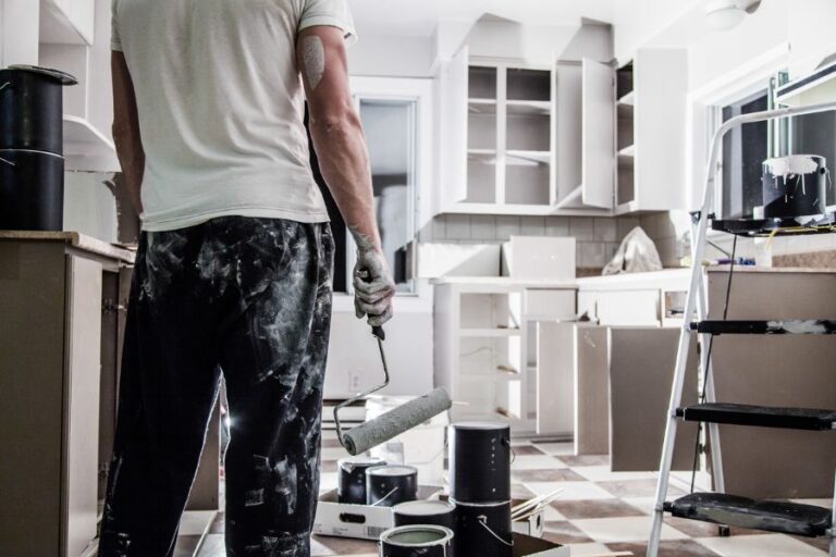 Man Painting Cabinets in Kitchen