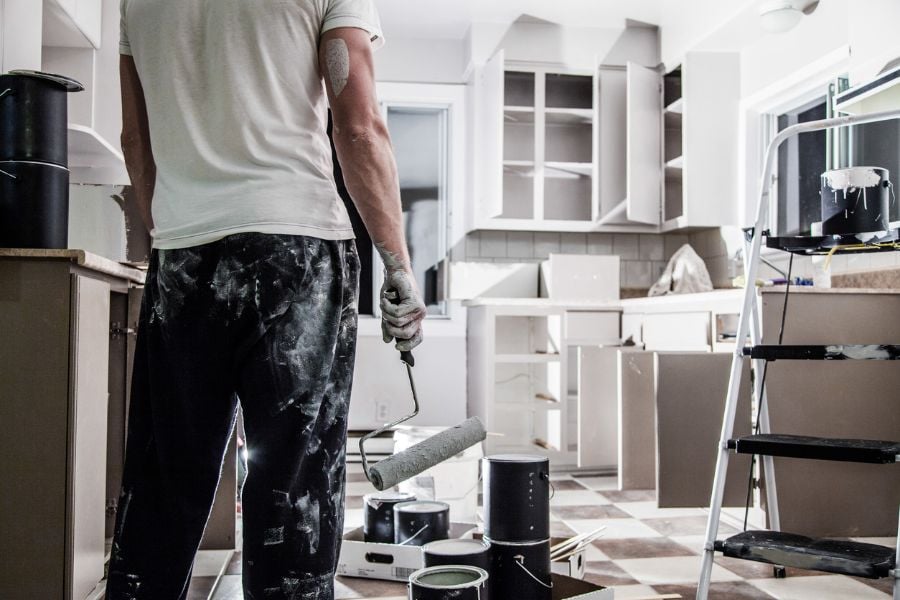Man Painting Cabinets in Kitchen
