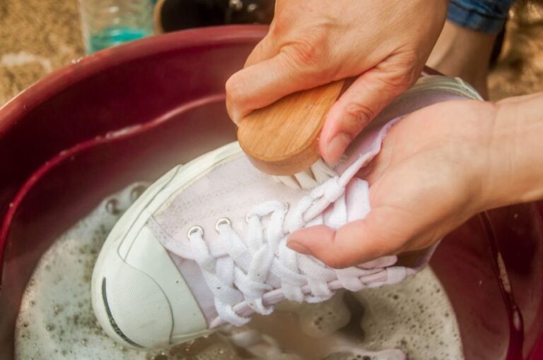 Hand Washing a Pair of White Shoes With a Scrub Brush