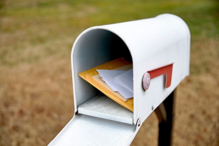 Open White Mailbox With Red Flag and Mail Inside