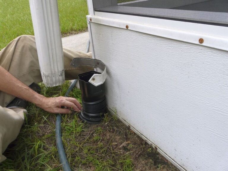 Man Installing a Connecter Between a Downspout and an Underground Extender