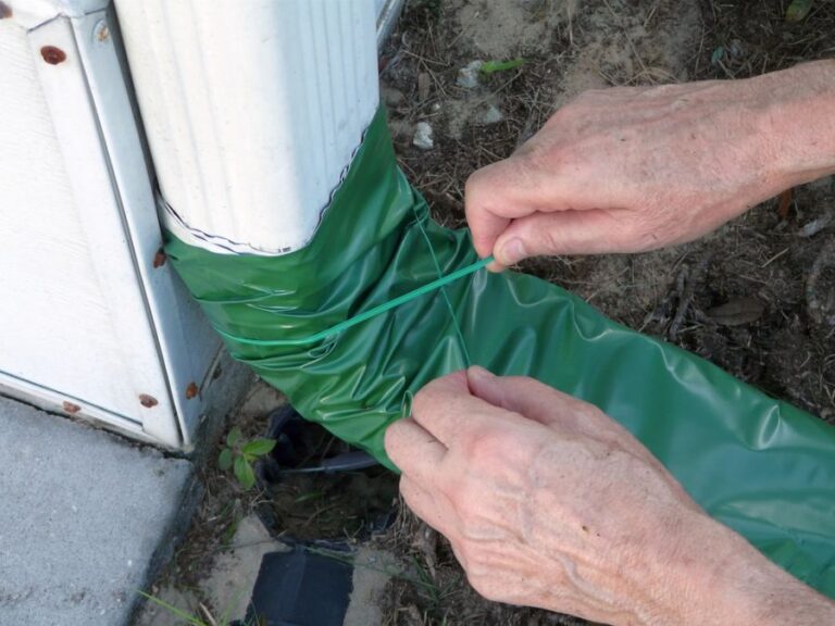 Man Installing a Rollout Downspout Extender on a Downspout