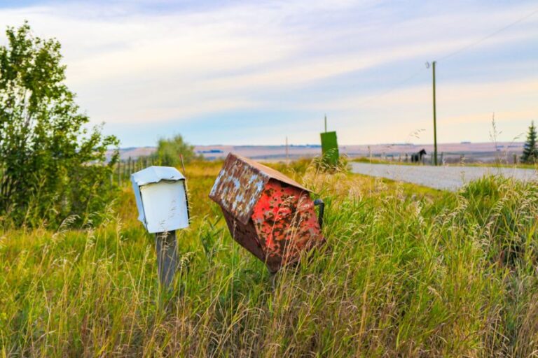 Two Old Mailboxes Leaning to the Side on a Country Road
