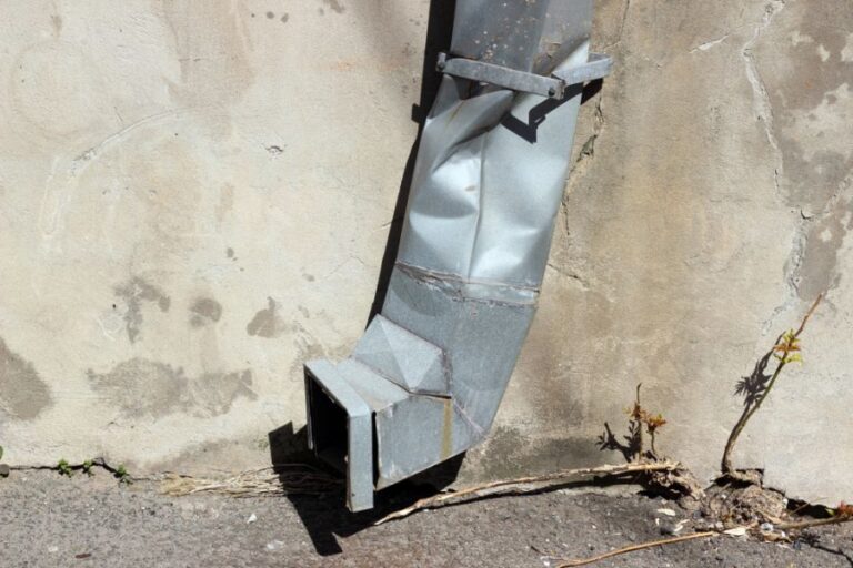 Crushed Metal Downspout on the Side of a Building