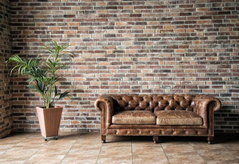Worn Leather Couch in Apartment With Brick Wall