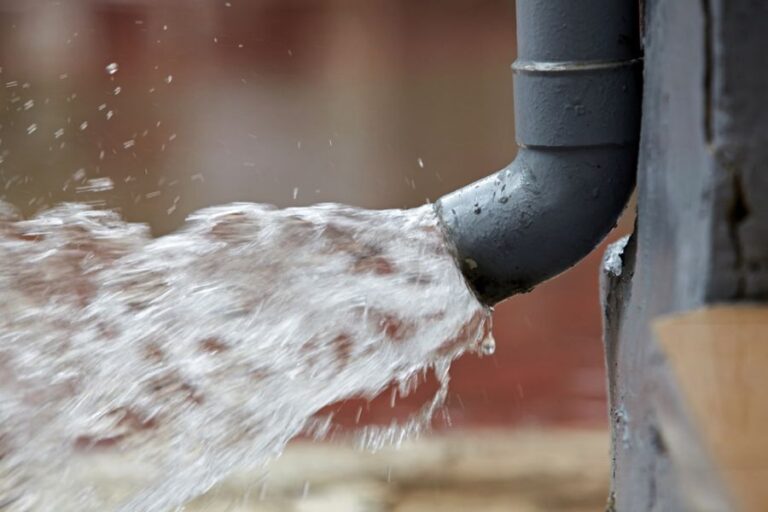 Rain Water Pouring From Plastic Rain Gutter