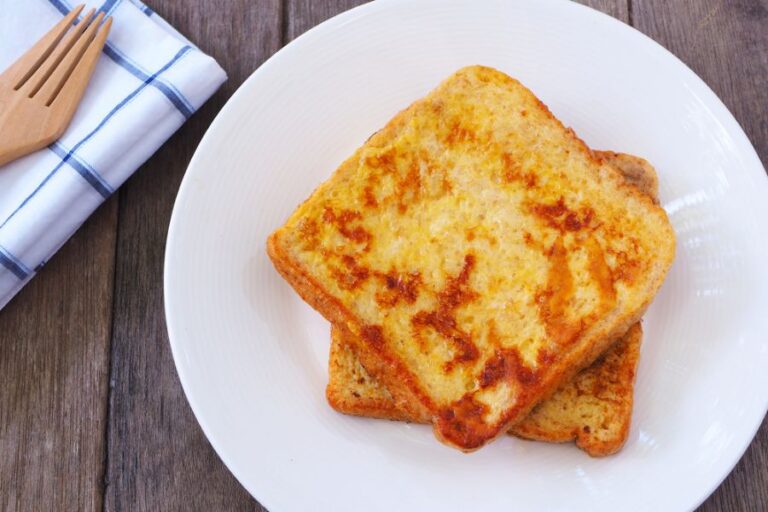 French Toast on a White Plate on a Wooden Table