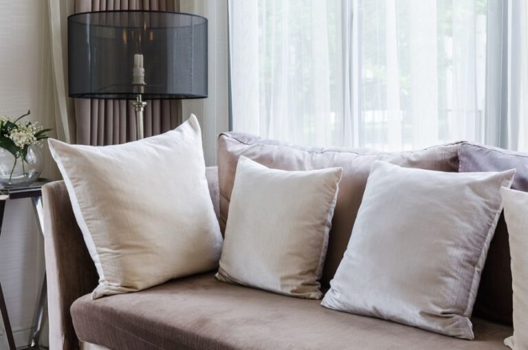 Gray Couch With Cushions in Need of Extra Stuffing