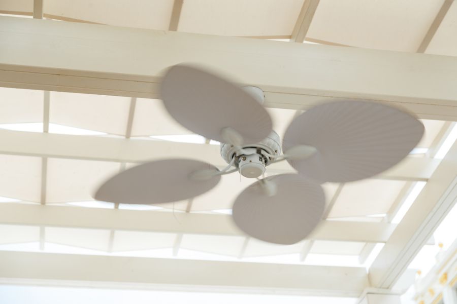 White Ceiling Fan Hanging From the Roof of a Pergola