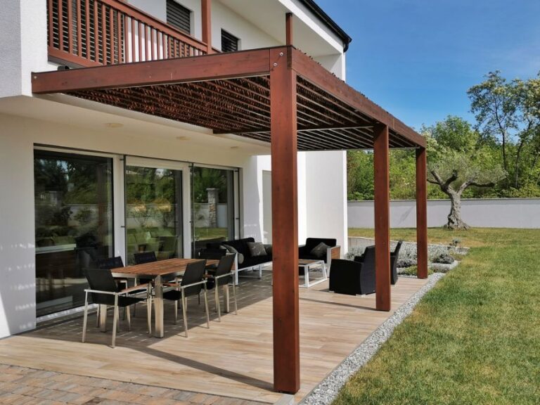 Pergola With a Thatched Roof Over a Back Terrace