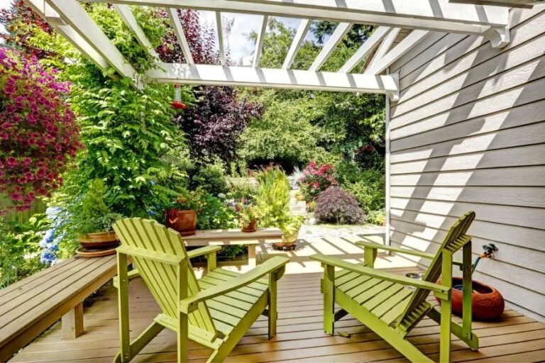 White Wooden Attached Pergola With Lots of Landscaping