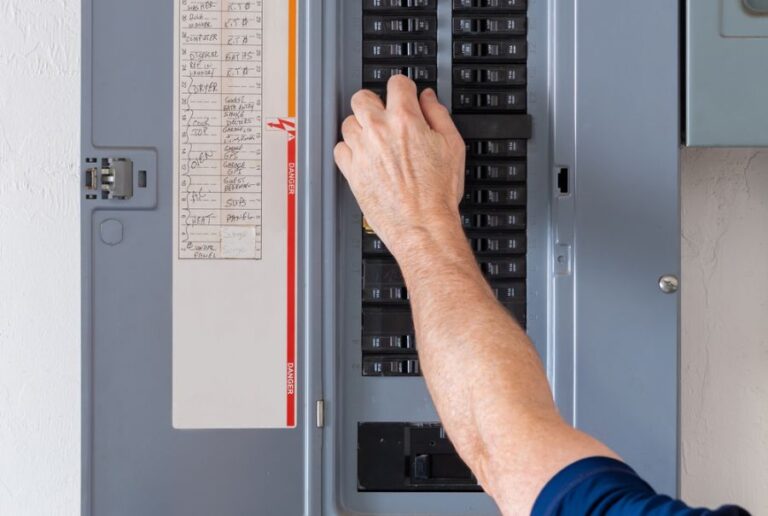 Man Flipping Breakers in an Electrical Panel