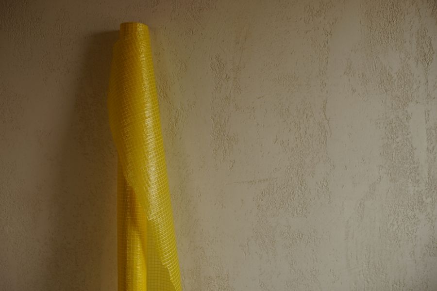 Roll of Yellow Vapor Barrier Leaning Against a Wall