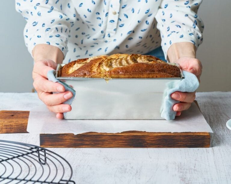 Woman Holding a Loaf Pan of Freshly Baked Banana Bread