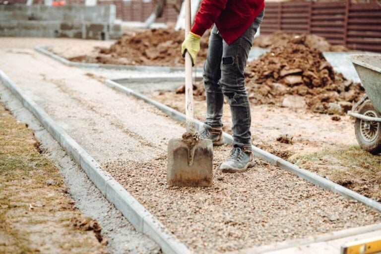 Worker Spreading Gravel as a Base for a Sidewalk