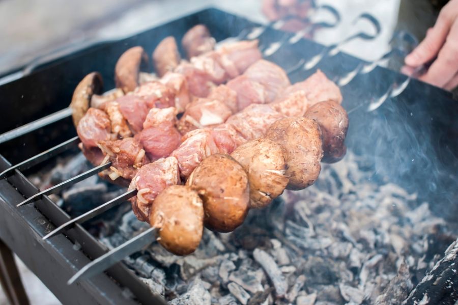 Man Using a Grill While on a Sidewalk